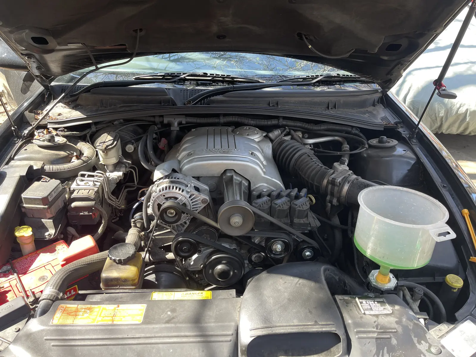 Holden Commodore VX engine bay with a coolant filling funnel in place