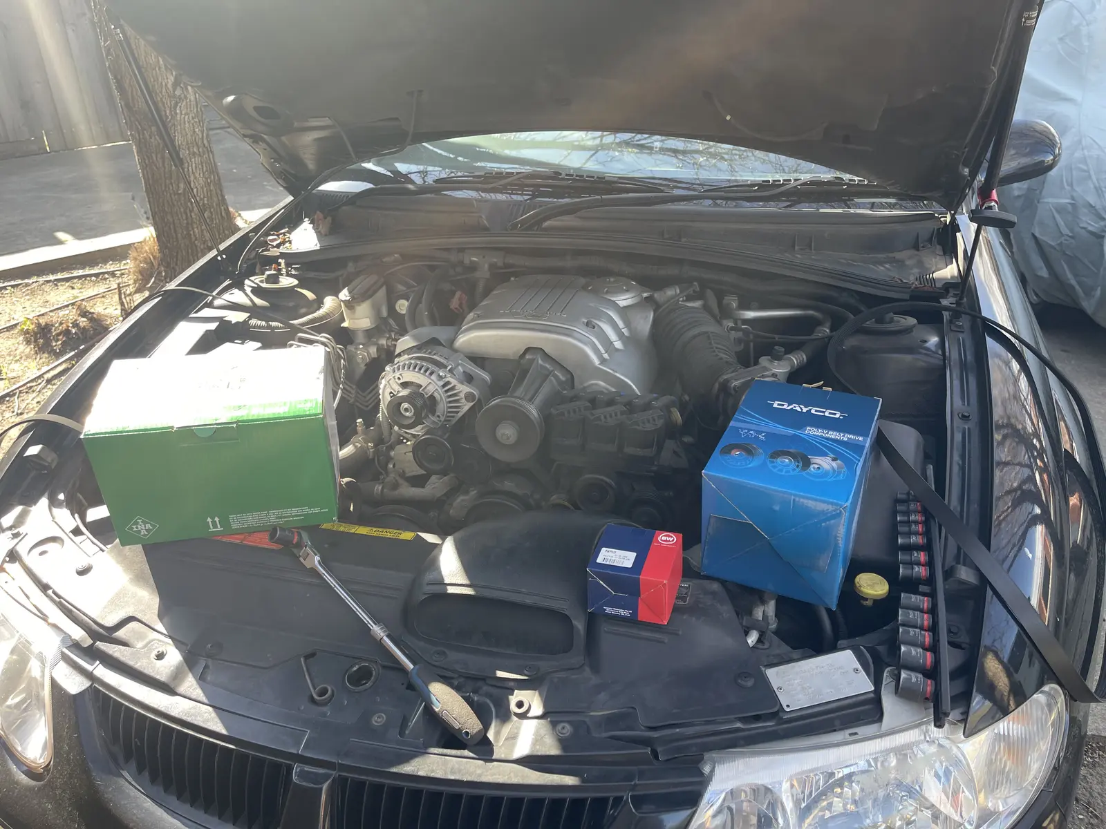 Supercharged Holden Commodore VX engine bay with repair parts and tools ready