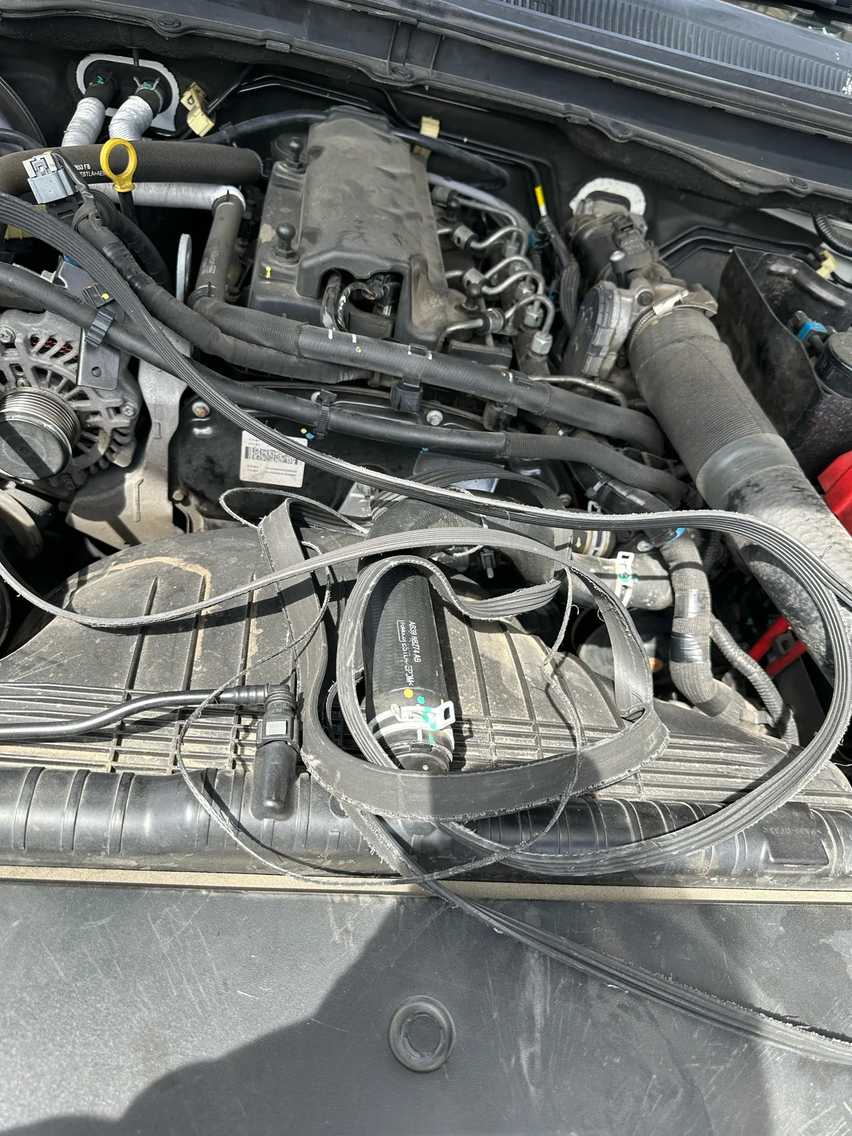 Shredded drive belt across the front of the 2016 Ford Ranger engine bay