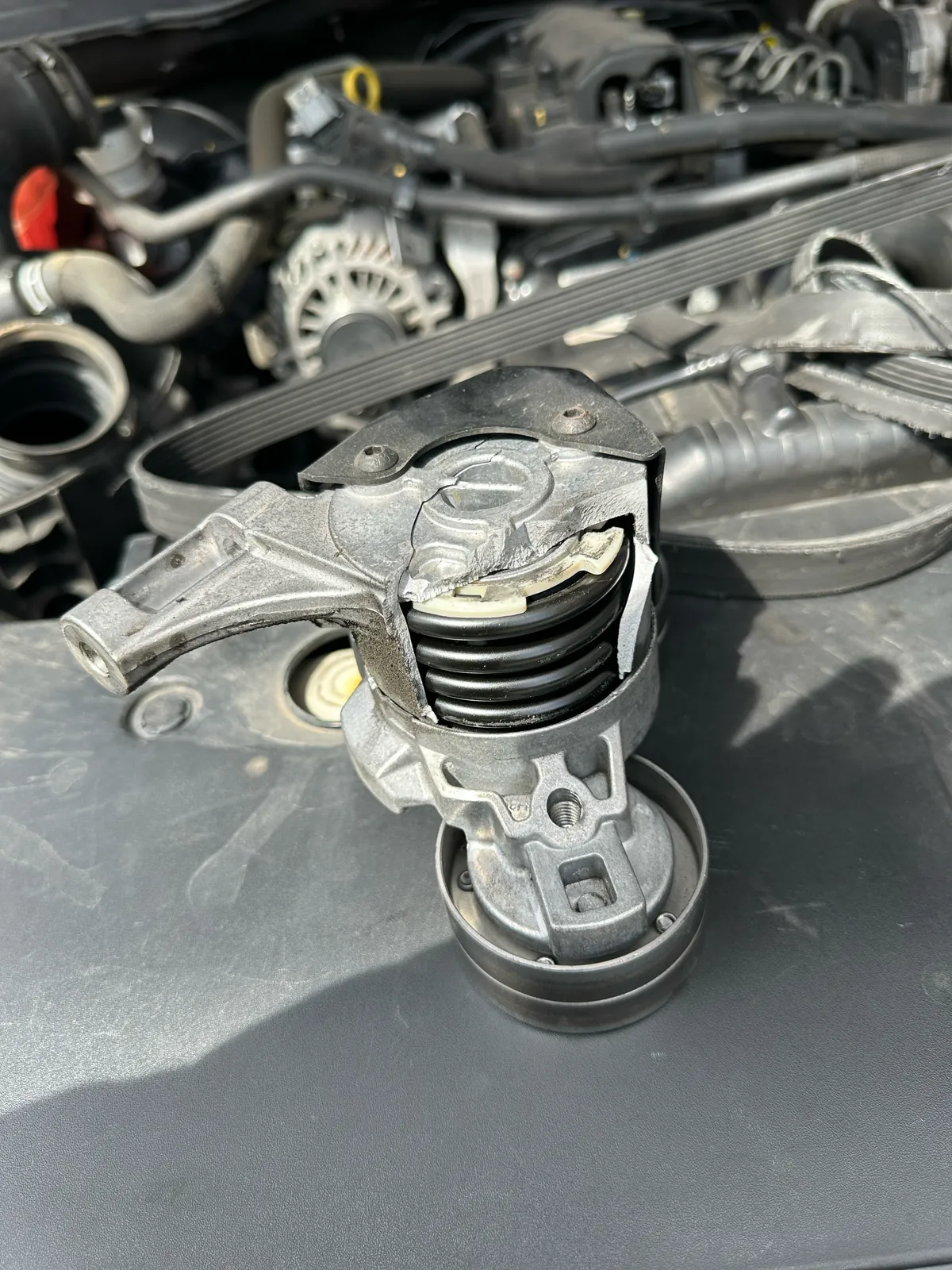 Close-up of the damaged drive belt tensioner removed from the Ford Ranger