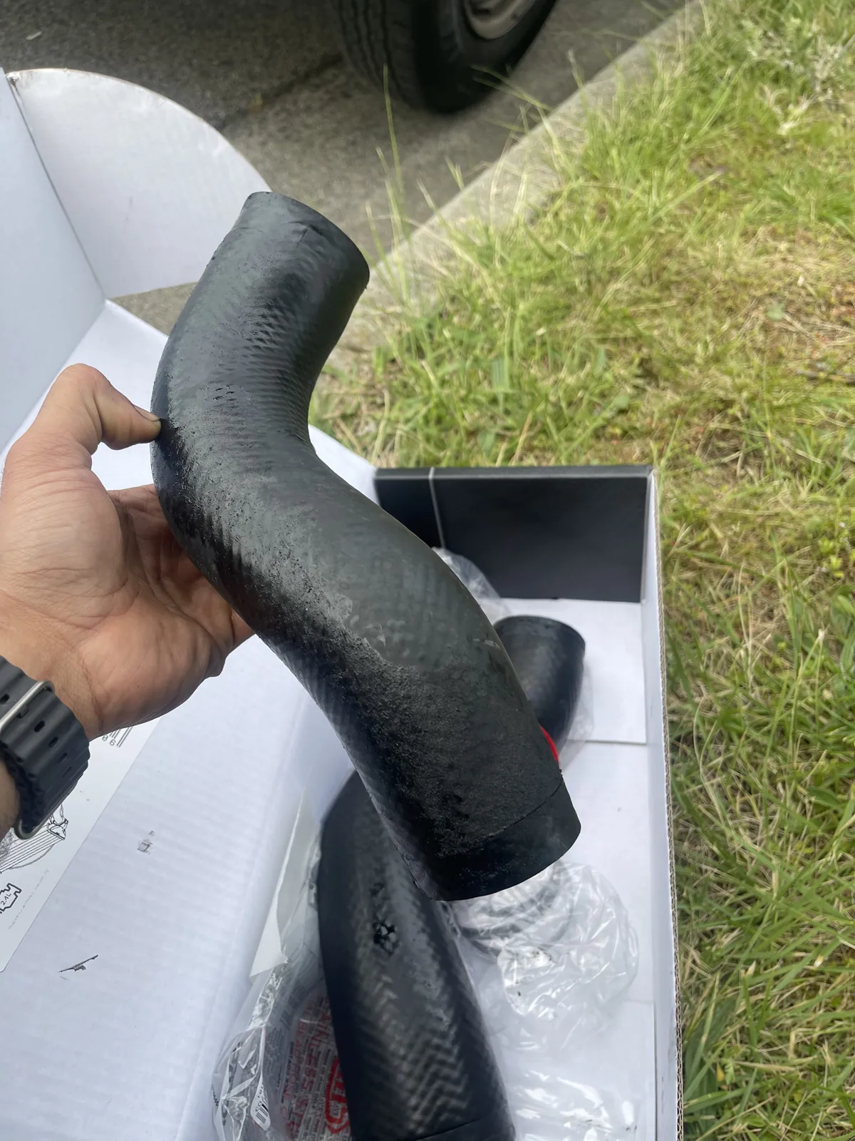 Removed Mitsubishi Triton intercooler hose showing damage near its end